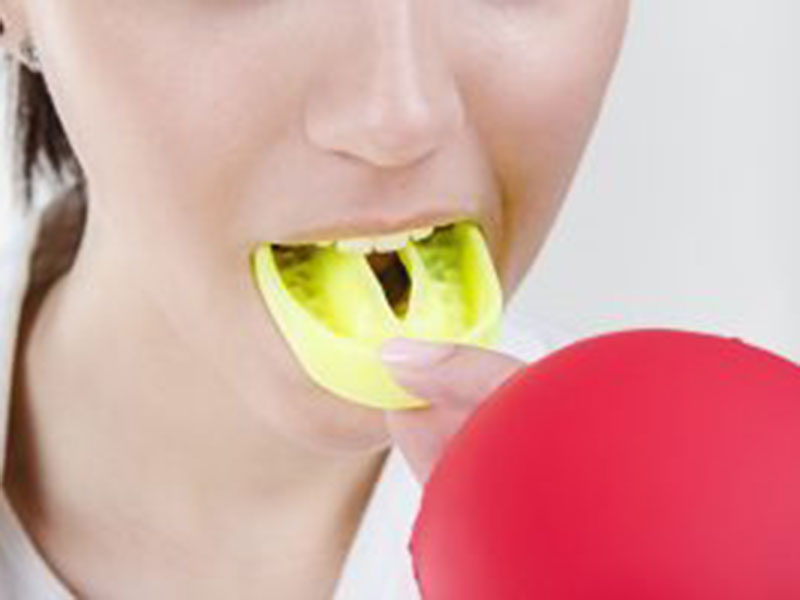 a woman using teeth mold for