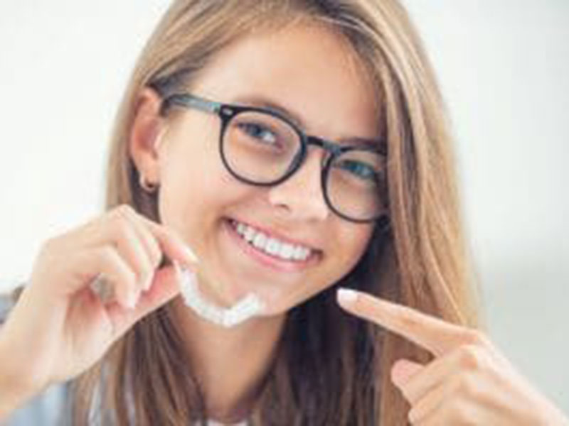 a girl showing teeth aligners