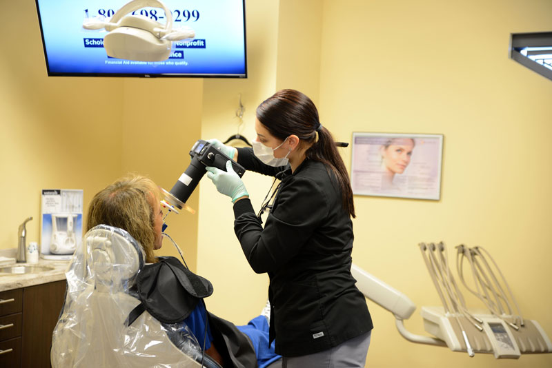 Dental assistant taking X-Rays of a patient's mouth