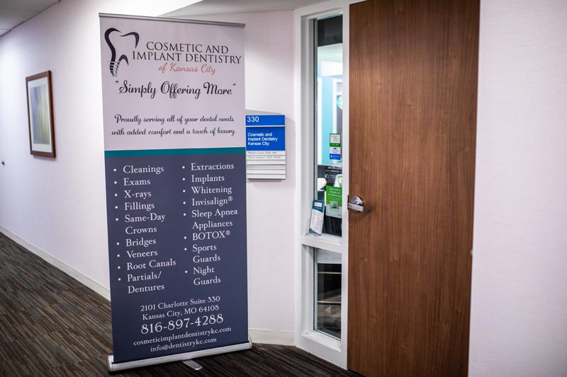 Informational banner outside of Cosmetic and Implant Dentistry of Kansas City's office